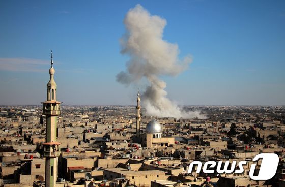 19일(현지시간) 시리아 반군 점령지인 동구타의 건물들 사이로 흰 연기가 피어 오르고 있다. © AFP=뉴스1