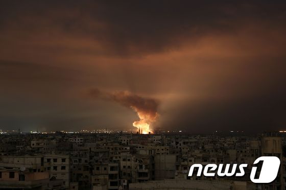 23일(현지시간) 시리아 다마스쿠스 외곽의 반군 도시 동구타 지역이 정부군의 무차별 공습을 받고 불길이 치솟고 있다. © AFP=뉴스1 