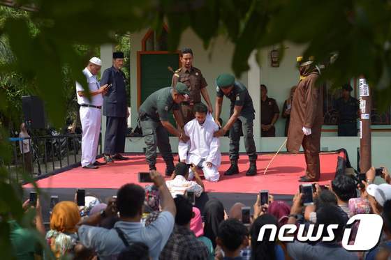 지난해 11월 인도네시아 아체주 반다아체에서 간통 혐의로 한 남성이 태형을 받고 있다. © AFP=뉴스1