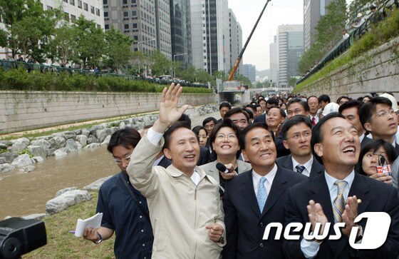 이명박 전 대통령이 서울시장 시절인 2005년 10월 청계천 개통식에서 시민들과 인사를 나누고 있다. © News1
