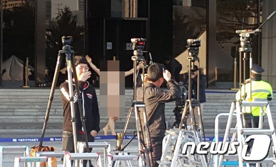 14일 오후 한 남성이 서울 서초동 서울중앙지검 현관 앞에서 나체소동을 벌이고 있는 모습.(독자제공) © News1