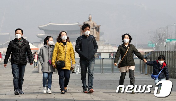 전국 대부분 지역에서 미세먼지가 '나쁨'을 보이고 있는 25일 오전 서울 광화문광장에서 시민들이 마스크를 쓰고 걷고 있다. 2018.3.25/뉴스1 © News1 박지수 기자