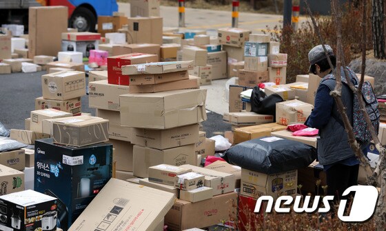 10일 오후 경기도 남양주 다산신도시의 한 아파트단지에서 입주민들이 바닥에 놓인 택배를 찾고 있다.  2018.4.10 © News1 이재명 기자