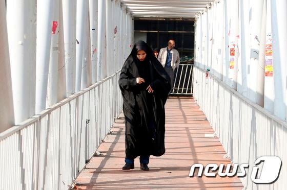 이란의 한 여성이 차도르를 입은채 걸어가고 있다. © AFP=뉴스1