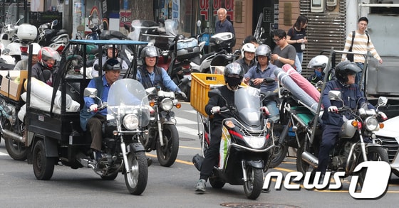 근로자의 날인 1일 오후 서울 동대문시장 일대에서 퀵서비스 운전자들이 오토바이를 타고 배달하고 있다. 2018.5.1/뉴스1 © News1 박지혜 기자