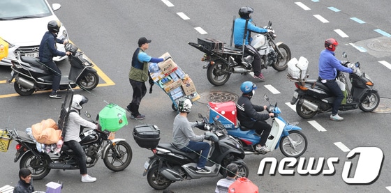 서울 동대문시장 일대에서 퀵서비스 운전자들이 오토바이를 타고 배달하고 있다. 2018.5.1/뉴스1 © News1 박지혜 기자