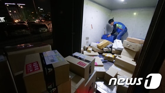 택배기사 박창환씨(42)가 거래처에서 받은 택배 상자를 트럭에 싣고 있다. © News1 황덕현 기자