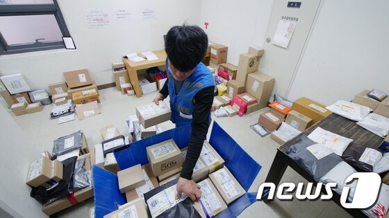 택배기사 박창환씨(42)가 상자를 세대별로 분류하고 있다. © News1 황덕현 기자
