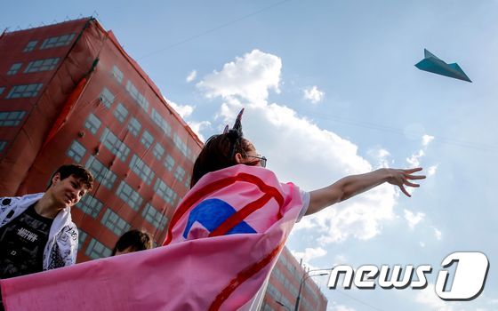 러시아 모스크바에서 한 여성이 텔레그램 차단 중단 시위에 참석해 텔레그램의 상징인 종이 비행기를 공중에 날리고 있다. © AFP=뉴스1