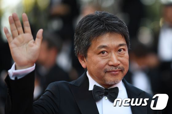Japanese director Hirokazu Kore-Edawaves as he arrives on May 19, 2018 for the closing ceremony and the screening of the film 