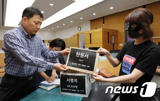 비웨이브 회원들이 23일 오후 서울 종로구 헌법재판소 민원실에서 낙태죄 폐지 주장 탄원서를 제출하고 있다 2018.5.23/뉴스1 © News1 박지수 기자
