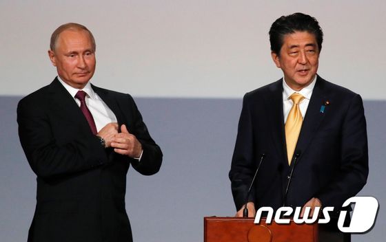 블라디미르 푸틴 러시아 대통령(왼쪽)과 아베 신조 일본 총리가 26일(현지시간) 모스크바 볼쇼이 극장에서 열린 '러·일 문화교류의 해' 행사에 참석 중이다. © AFP=뉴스1