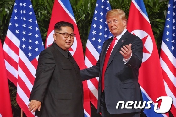 도널드 트럼프 미국 대통령과 김정은 북한 국무위원장이 12일 오전 북미 정상회담이 열린 싱가포르 센토사섬 카펠라호텔에서 인사를 나누고 있다. (싱가포르통신정보부 제공) 2018.6.12/뉴스1
