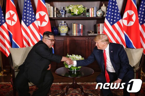 김정은 북한 국무위원장과 도널드 트럼프 미국 대통령이 12일 싱가포르 센토사 섬 카펠라호텔에서 만나 인사를 나누고 있다. (싱가포르통신정보부 제공)2018.6.12/뉴스1