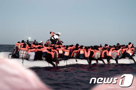 9일(현지시간) 지중해SOS에 의해 구출된 난민들이 구조선 '아쿠아리우스'에 승선하기 위해 고무보트를 타고 이동하고 있다. © AFP=뉴스1