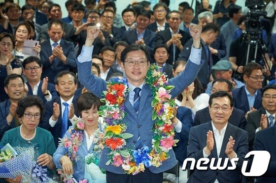 14일 당선이 확실시 되는 순간 김경수 더불어민주당 경남도지사 후보가 두손을 번쩍들어 지지자들의 박수에 답하고 있다.  © News1