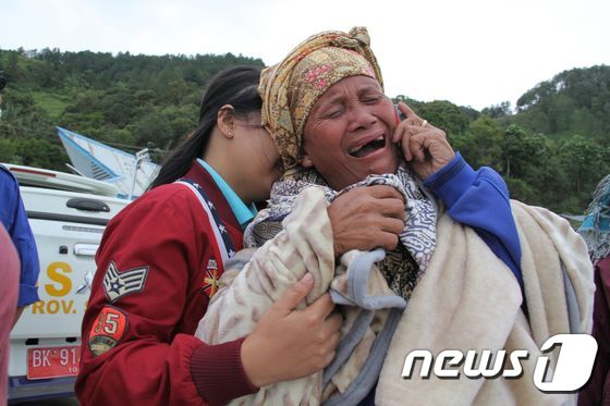 17일 침몰한 토바호에서 가족이 실종됐다는 소식을 듣고 오열하는 한 여성. © AFP=뉴스1