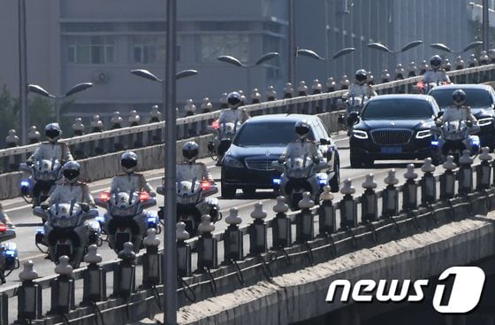 김정은 국무위원장을 비롯한 북한 대표단이 탄 것으로 보이는 검은색 차량행렬이 19일 오후 중국 공안 오토바이의 선도 아래 베이징 시내를 달리고 있다. © AFP=뉴스1