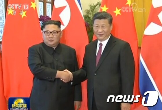 김정은 북한 국무위원장(왼쪽)과 시진핑 중국 국가주석이 19일 중국 베이징 인민대회당에서 세번째 회동에 앞서 악수하고 있다. (CCTV 캡처) 2018.6.19/뉴스1