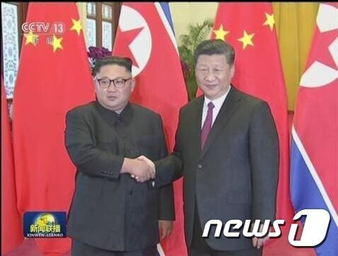 김정은 북한 국무위원장(왼쪽)과 시진핑 중국 국가주석이 19일 오후 베이징 인민대회당에서 열린 정상회담에 앞서 악수하고 있다. (중국 중앙TV 캡처) © News1