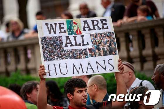 20일(현지시간) 세계난민의 날을 맞아 행동가들이 이민을 지지한다는 팻말을 들고 시위에 나서고 있다. © AFP=뉴스1