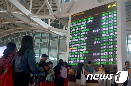 29일 응우라라이 공항에서 항공편 일정을 확인하고 있는 사람들 © AFP=뉴스1