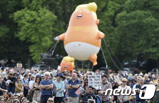 도널드 트럼프 미국 대통령을 조롱하는 '아기 트럼프' 대형 풍선을 띄워 올린 영국인들이 반대 시위에 나서고 있다. © AFP=뉴스1