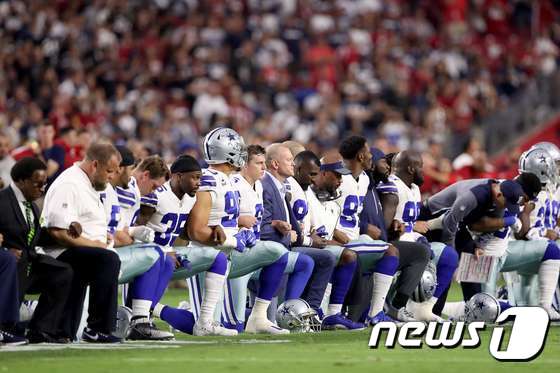 지난해 9월25일 NFL 댈러스 카우보이스 선수들이 국가가 연주되는 동안 무릎을 꿇고 있다. © AFP=뉴스1