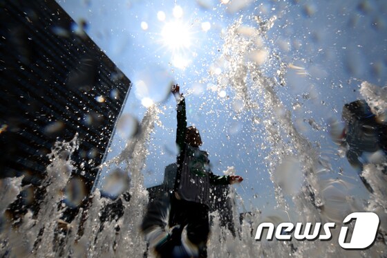 서울의 낮 최고기온이 36도를 기록하는 등 연일 폭염이 이어지고 있는 21일 오후 서울 광화문광장 분수대를 찾은 아이들이 물놀이를 하며 더위를 식히고 있다. 2018.7.22/뉴스1 © News1 구윤성 기자