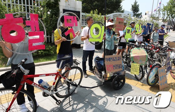 자전거문화사회적협동조합 등 시민단체 회원들이 21일 오후 서울청사 앞에서 기자회견을 열고 자전거 헬멧 착용 의무화 폐지를 촉구하고 있다. 이들은 