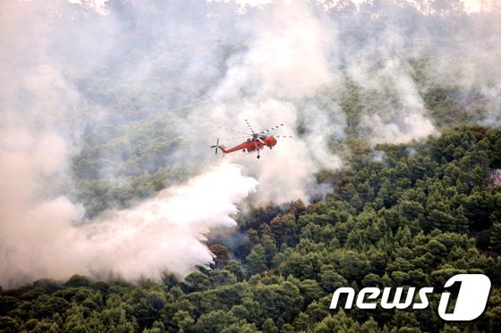 25일(현지시간) 그리스 키네타 야산에서 소방헬기가 진화작업을 벌이고 있다. © AFP=뉴스1