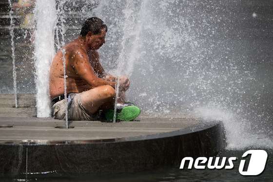 공원 분수 위에 앉아 더위를 식히는 한 남성. (자료사진) © AFP=뉴스1