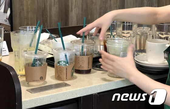 지난 2018년 8월 한 카페 직원이 고객들이 사용한 일회용 컵을 정리하고 있다.  당시 환경부는 커피전문점과 패스트푸드점을 대상으로 한 일회용컵 남용을 단속했었다. © News1 박지혜 기자