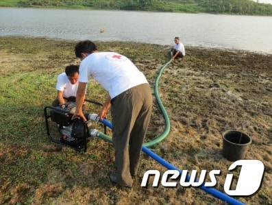 북한조선적십자회 관계자들이 양수기를 이용해 물을 끌어올리고 있다. (북한조선적십자회) © News1
