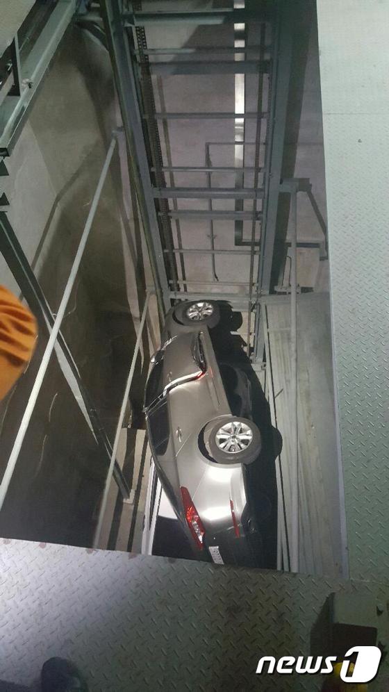 20일 오후 10시 16분쯤 부산 연제구에 있는 한 주차타워에서 K5가 지하주차장 2층으로 추락해 아반떼를 덮쳤다. K5가 옆으로 전도된 모습.(부산지방경찰청 제공)© News1