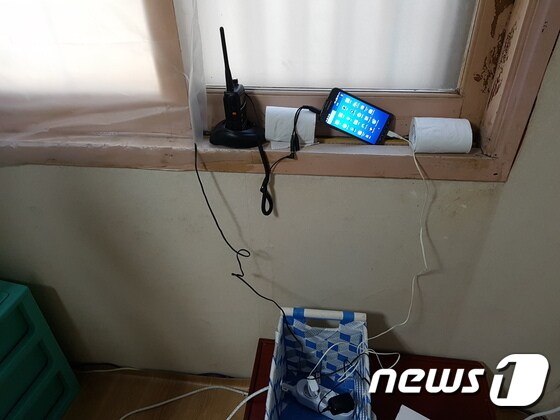 장의업체가 마련한 도청상황실에 놓여있던 무전기와 실시간 중계용 휴대전화.(부산지방경찰청 제공)© News1