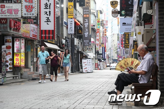 5일 서울 도심의 한 식당가에서 가게 주인이 손님을 기다리고 있다.  2018.8.5/뉴스1 © News1 신웅수 기자