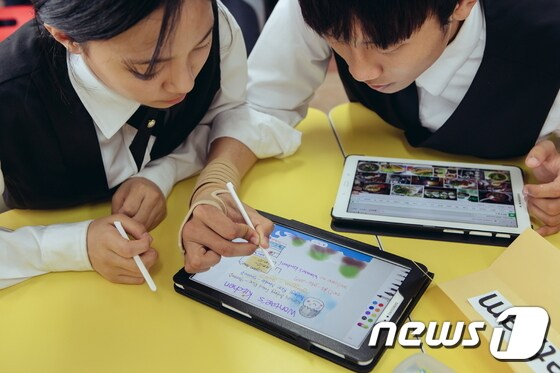 지난해 선정되어 삼성전자 '스마트 스쿨'을 지원받은 한국외식과학고등학교 학생들이 태블릿과 전자칠판을 통해 스스로 검색하고 만들어가는 모둠 활동을 하고 있다.(삼성전자 제공) © News1