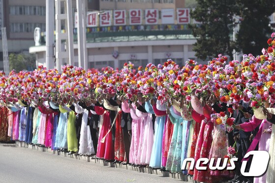 18일 평양 순안공항에서 평양시내로 향하는 거리에 시민들이 꽃술을 흔들며 문재인 대통령을 환영하고 있다.2018.9.18/뉴스1 © News1 평양사진공동취재단