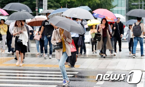 가을비가 내리는 21일 오전 서울 광화문광장 인근에서 시민들이 우산을 쓰고 발걸음을 재촉하고 있다. 2018.9.21/뉴스1 © News1 이승배 기자