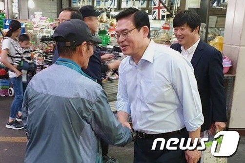 자유한국당 정우택 의원이 21일 청주 육거리시장을 찾아 주민과 악수를 나누고 있다. (정우택 의원실 제공) © News1