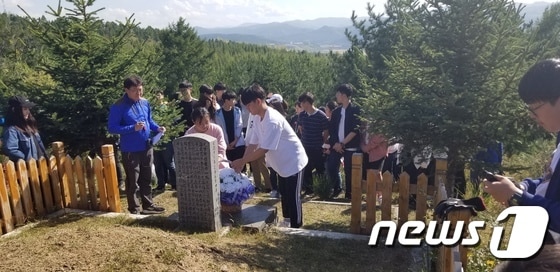 연변한국국제학교 학생과 교사들이 독립운동가의 묘소에서 추모식을 진행하고 있다. © News1
