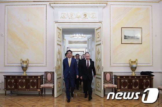 아베 신조 일본 총리(왼쪽)과 블라디미르 푸틴 러시아 대통령이 22일(현지시간) 크렘린궁에서 열린 정상회담 뒤 기자회견장으로 입장하고 있다. © AFP=뉴스1