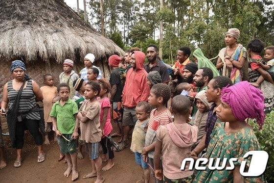 파푸아뉴기니에서 마녀로 몰린 한 여성의 집 앞에 모여있는 군중. © AFP=뉴스1