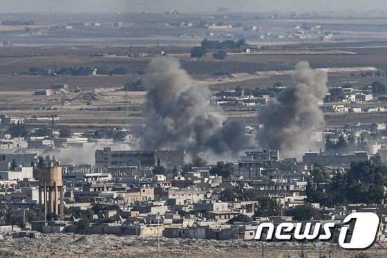 13일(현지시간) 터키군의 시리아 북동부 지역 쿠르드족에 대한 공격으로 국경도시 라스 알-아인에서 연기가 솟아오르고 있다. © AFP=뉴스1 © News1 우동명 기자