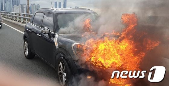 15일 오전 9시20분쯤 부산 광안대교 상판을 주행하던 BMW 미니쿠페에서 불이 나 10여분만에 진화됐다. 승용차가 불길에 휩싸인 모습.(부산지방경찰청 제공)© 뉴스1