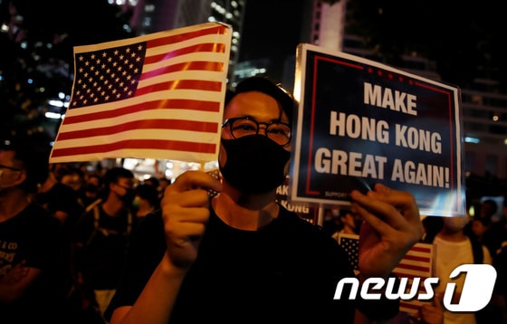 한 시위 참가자가 성조기와 트럼프 대통령의 선거 구호를 흉내낸 '홍콩을 다시 위대하게' 팻말을 들고 있다. © 로이터=뉴스1 © News1 