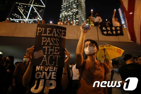 홍콩 시위대가 '홍콩 인권법'을 포기하지 말고 통과시키라는 팻말을 들고 시위를 벌이고 있다. © 로이터=뉴스1 © News1 