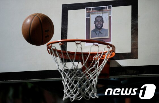 홍콩의 시민들이 NBA의 스타인 르브론 제임스의 얼굴을 농구 백보드에 달아 놓고 그를 맞히는 게임을 하고 있다. © 로이터=뉴스1 © News1 박형기 기자