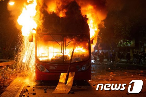 20일 (현지시간) 산티아고에서 지하철 요금 인상으로 촉발된 칠레 반정부 시위대의 방화로 버스가 불에 타고 있다. © AFP=뉴스1 © News1 우동명 기자